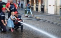 Jugendfeuerwehr lehrt Kinder, einen Feuerwehrschlauch festzuhalten